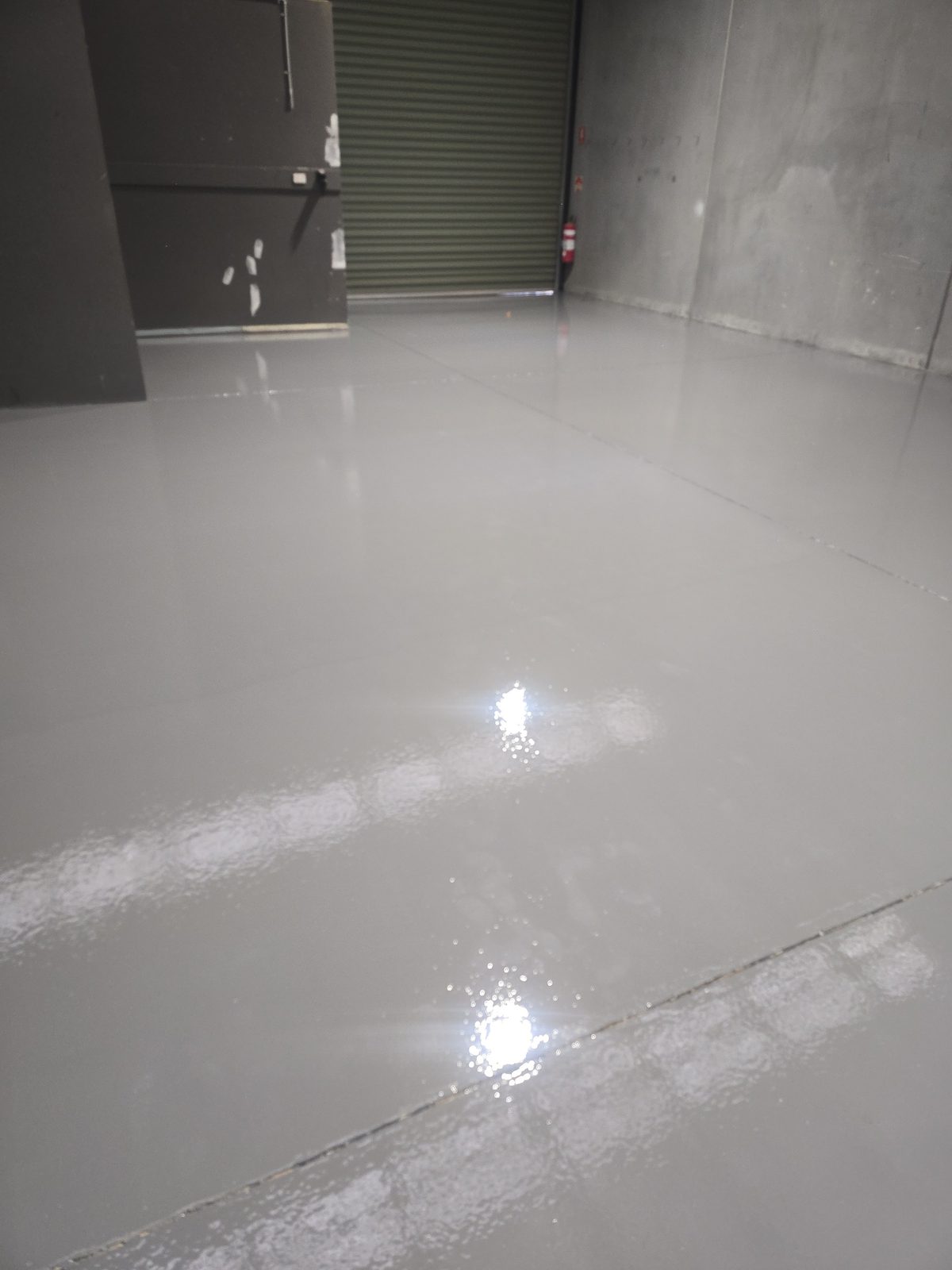 Glossy coated concrete floor, showing the film-forming finish a topical coating produces
