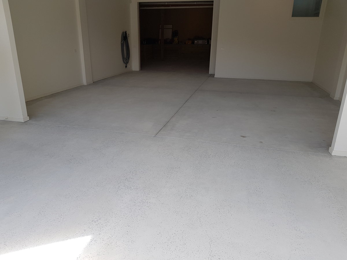 Bare grey concrete garage floor before an epoxy coating is applied