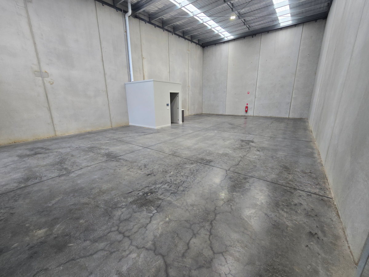 Cleaned concrete warehouse floor lit by roof skylights along the length of the bay