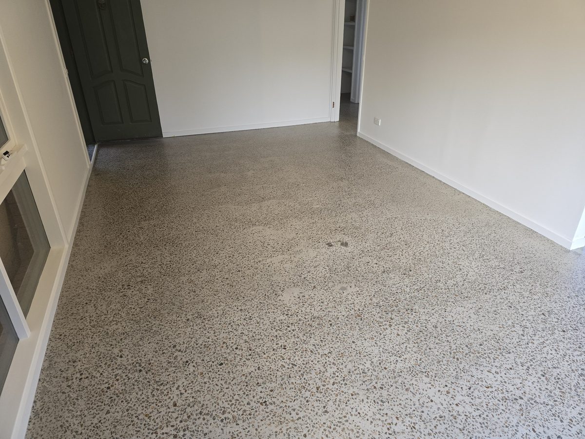 Grind and seal concrete floor with a light, speckled finish in a bright room