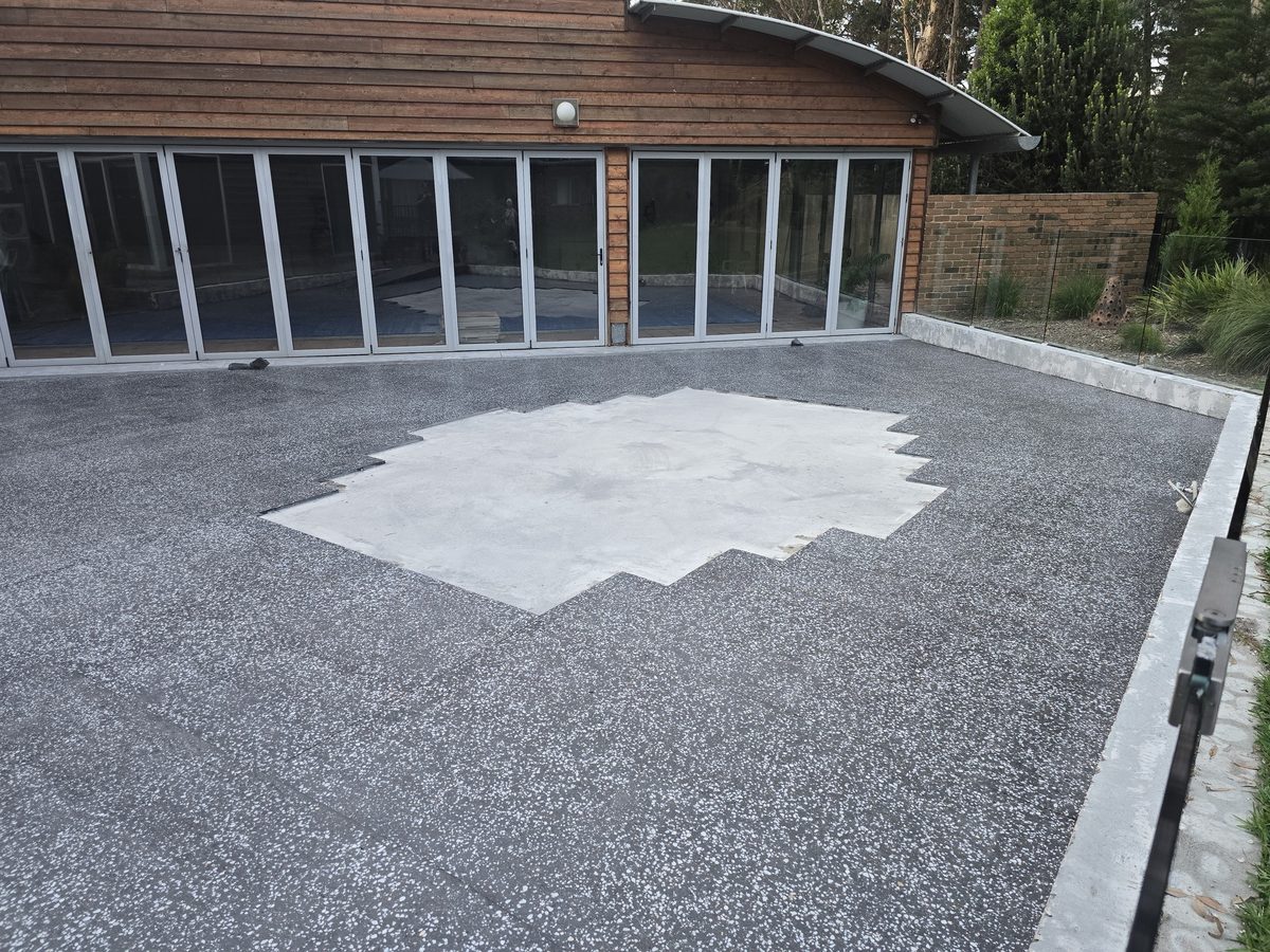 Charcoal grind-and-seal concrete finish with a clean, even sheen