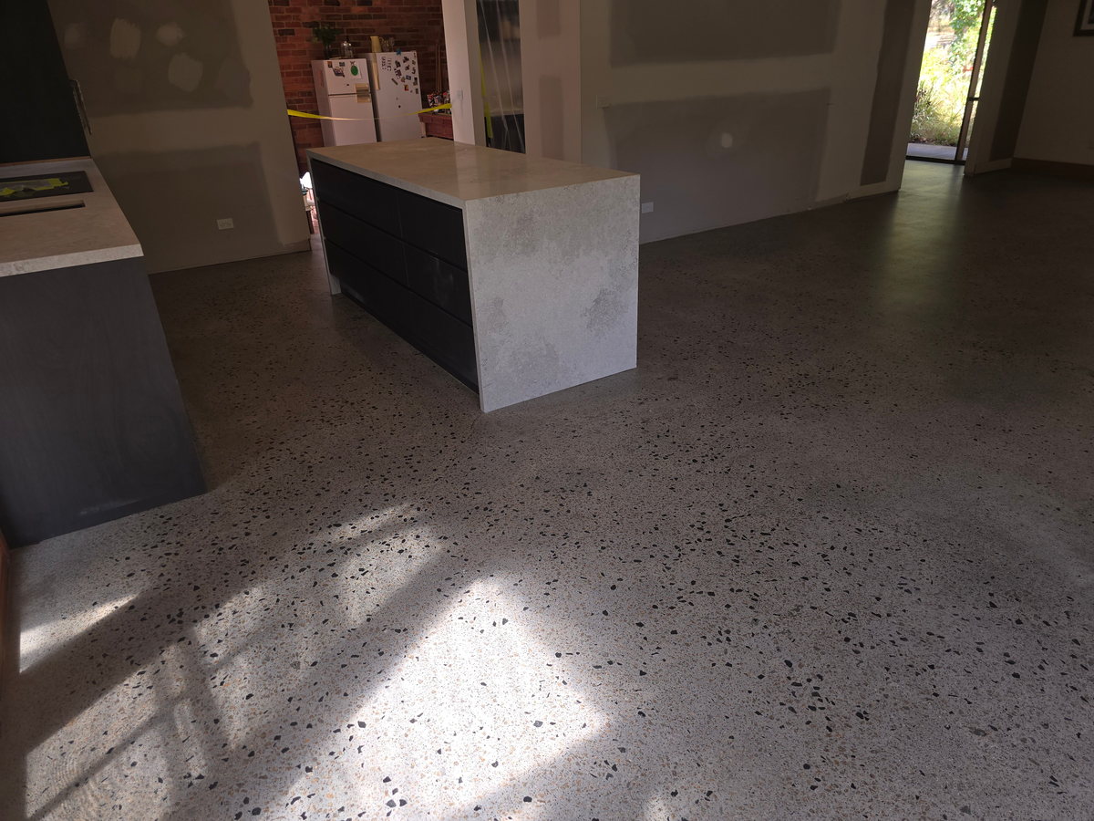 Sealed concrete floor running beneath a kitchen island