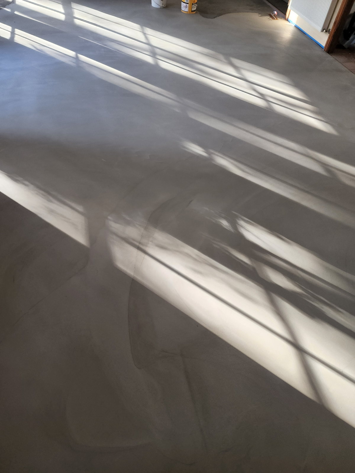 Microcement surface photographed in raking light showing its hand-applied texture
