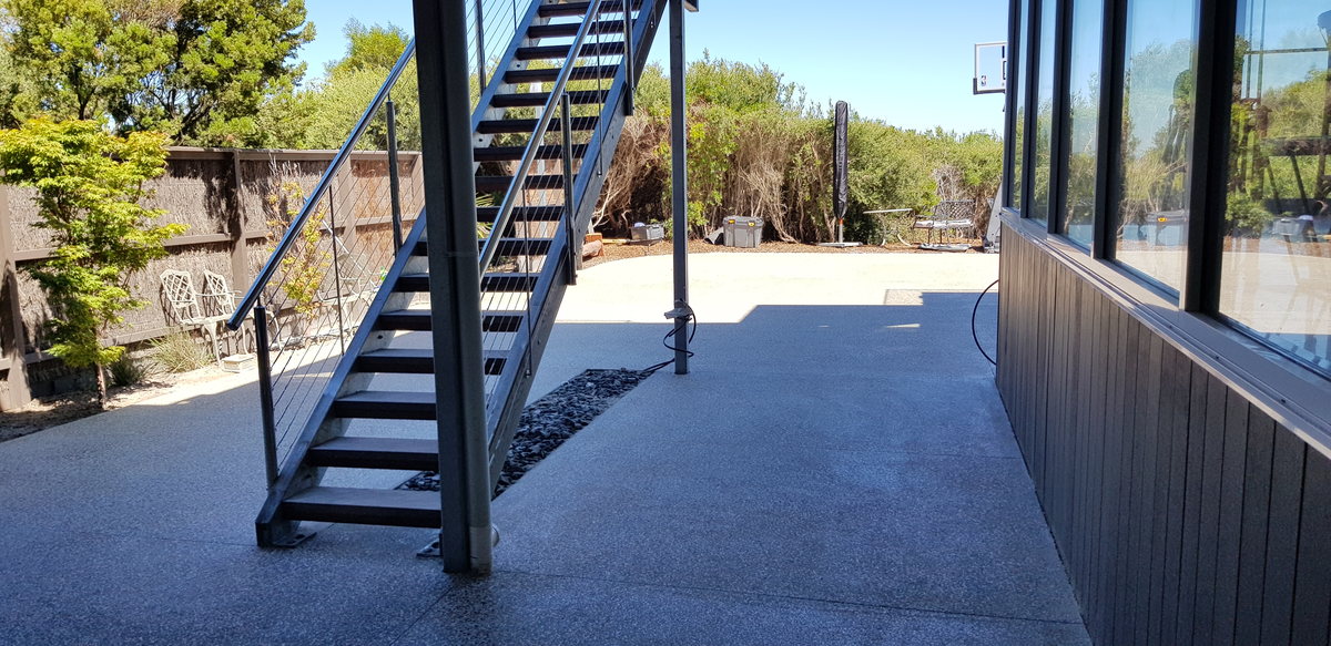 Completed exposed-aggregate pavilion finish under a covered alfresco area
