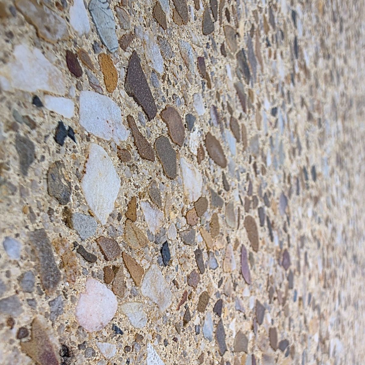 Macro detail of multicoloured stone aggregate in a sealed pavilion finish surface