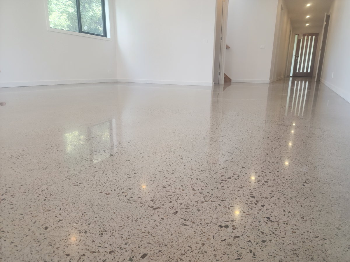 Polished concrete floor in a bright residential room with large windows