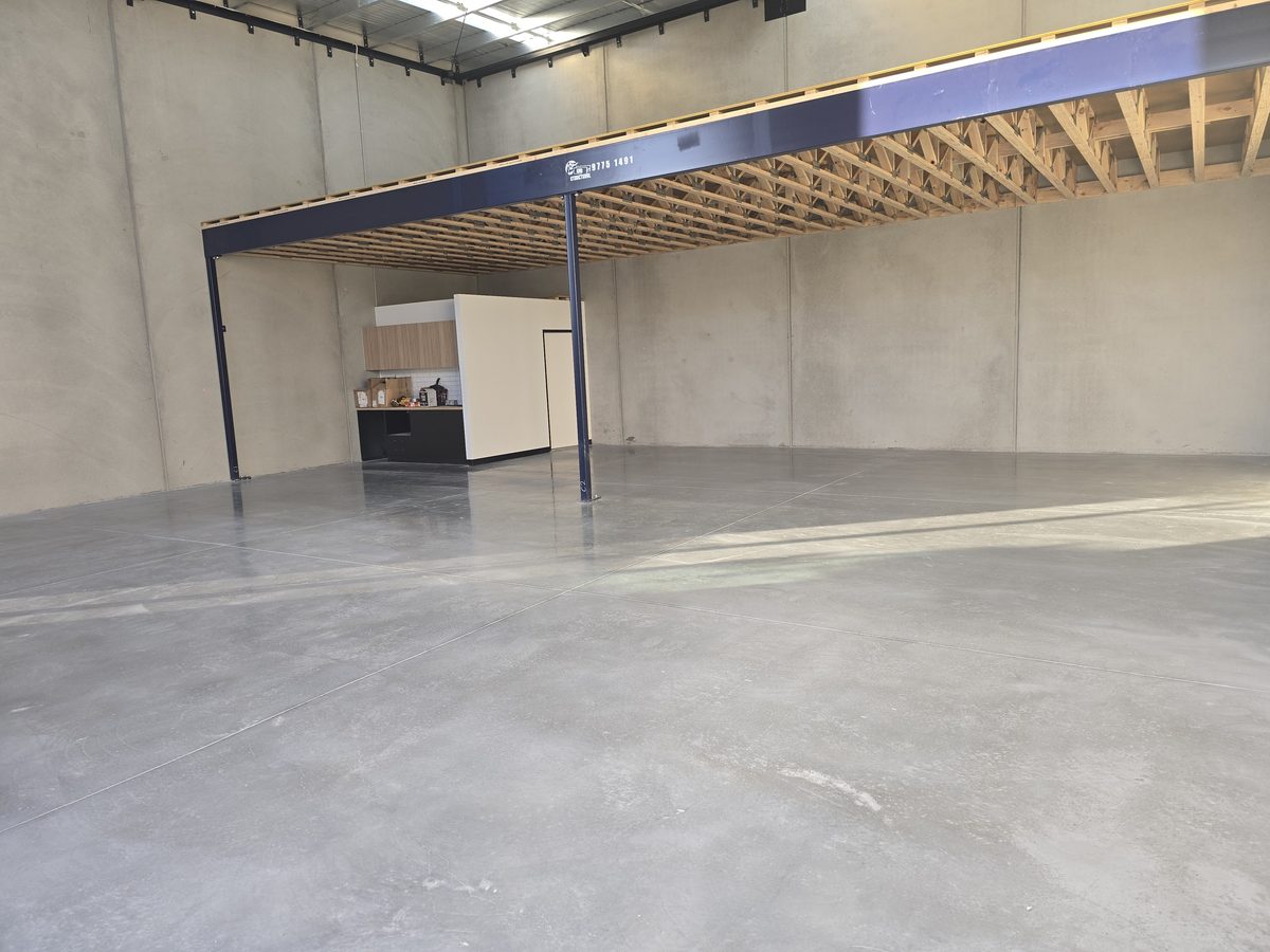 Honed concrete floor reflecting light in a large industrial space