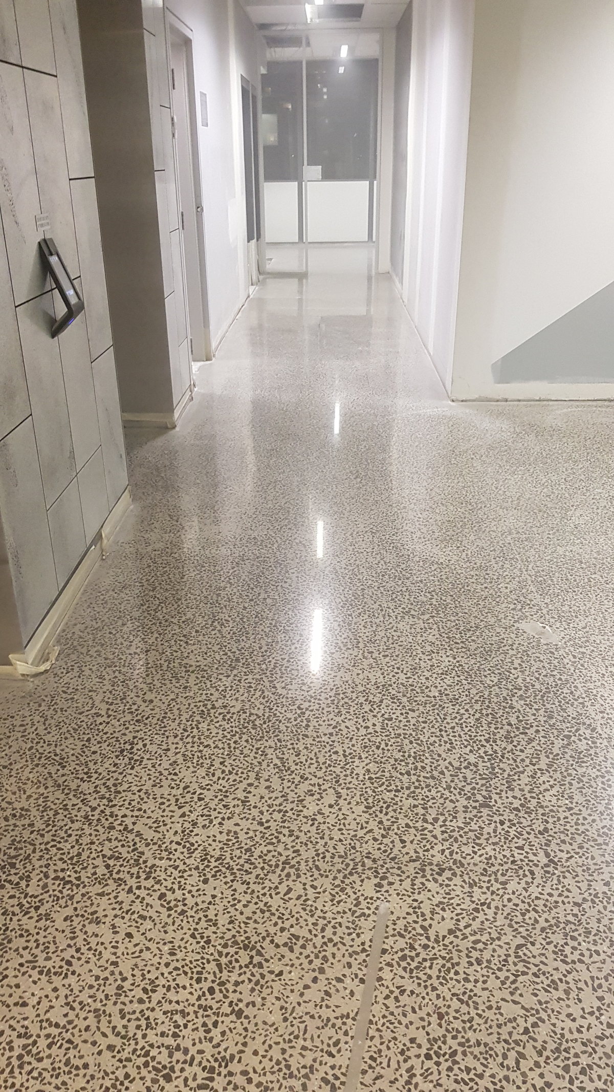 Polished concrete corridor floor showing control joints running across the finished surface